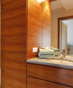Łazienka z brązowymi frontami szafek oraz z kamiennym blatem