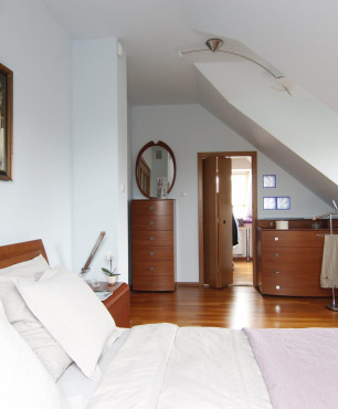 Sypialnia na poddaszu w stylu klasycznym z obrazem na ścianie
