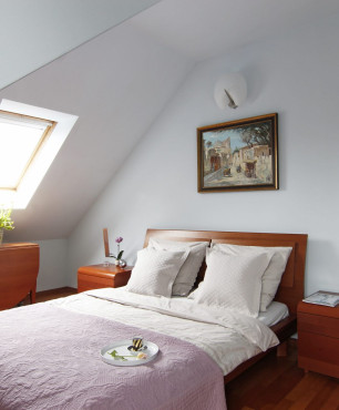 Sypialnia z białymi ścianami oraz z oknem dachowym