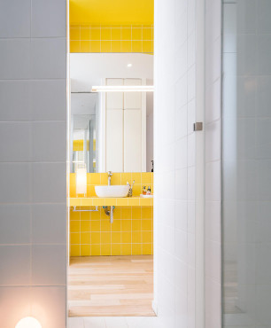 Słoneczna i jasna łazienka z żółtymi płytkami na ścianie