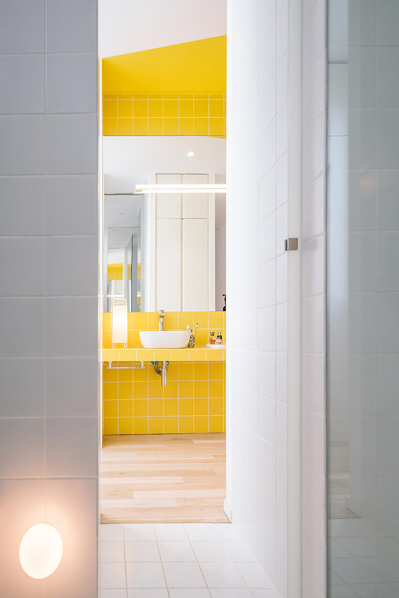 Słoneczna i jasna łazienka z żółtymi płytkami na ścianie