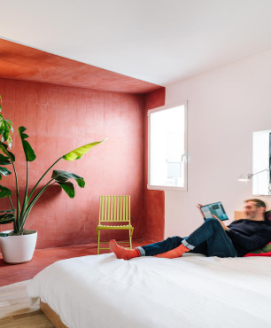 Duża sypialnia z drewnianym łóżkiem kontynentalnym oraz z kącikiem z roślinami