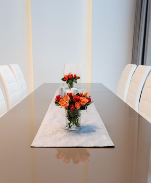 Jadalnia z dużym stołem ze szklanym blatem oraz z tapicerowanymi krzesłami
