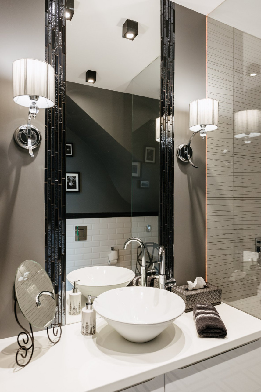 Nowoczesna łazienka z prostokątnym lustrem w czarnej oprawie oraz z okrągłym zlewem nablatowytm