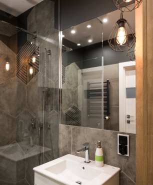 Mała łazienka z prysznicem i szarymi płytkami heksagonami ułożonymi na ścianie