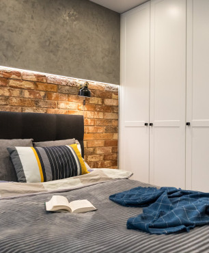 Sypialnia w stylu skandynawskim z biała szafą i kinkietami nad łóżkiem