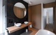 Nowoczesna łazienka z dużym, okrągłym lustrem i dwoma zlewami nablatowytmi