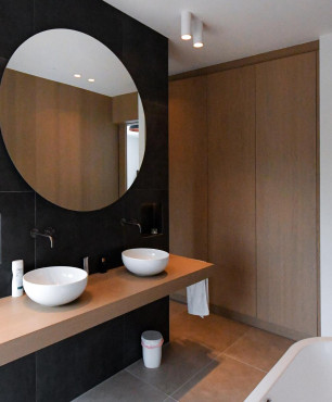 Nowoczesna łazienka z dużym, okrągłym lustrem i dwoma zlewami nablatowytmi