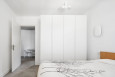 Sypialnia z białym kolorem ścian oraz z białą szafą