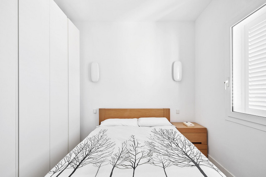 Klasyczna sypialnia z białą szafą i białymi konkietami