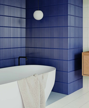 Aranżacja łazienki z wanną, owalną z płytkami na ścianie z głęboką strukturą w kolorze DARK BLUE oraz płytkami w kolorze BIANCO na podłodze