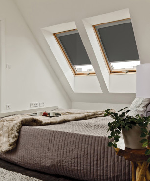 Sypialnia na poddaszu z cegłą na ścianie oraz z oknami dachowymi