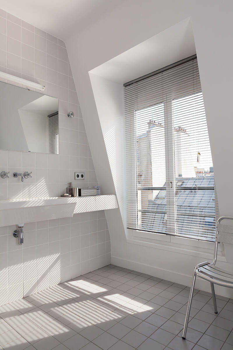 Klasyczna łazienka z dużym oknem i białym zlewem