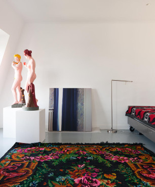 Salon na poddaszu z dywanem z folklorystycznym wzorem