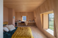 Sypialnia z boazerią na ścianie oraz jasną wykładziną