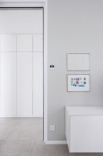 Jasny, klasyczny korytarz z białą, niska szafką stojącą