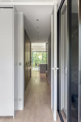 Długi korytarz z imitacją drewnianych paneli na podłodze