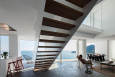 Salon z drewnianymi schodami z zabudowaną balustradą