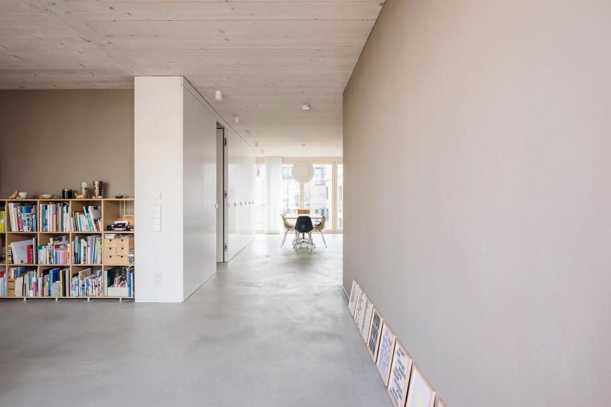 Salon z betonową podłogą i z biblioteczką