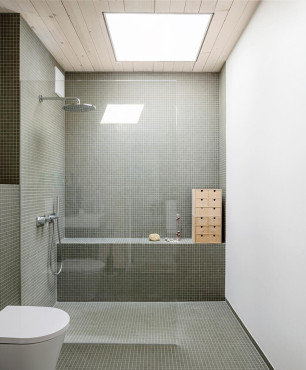 Łazienka z prysznicem walk-in oraz z białą muszlą wiszącą