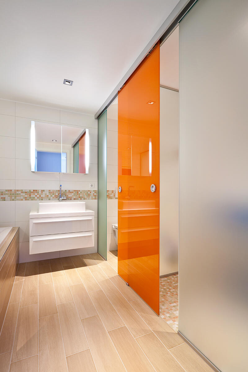 Łazienka z przesuwanymi drzwiami w kolorze pomarańczowym
