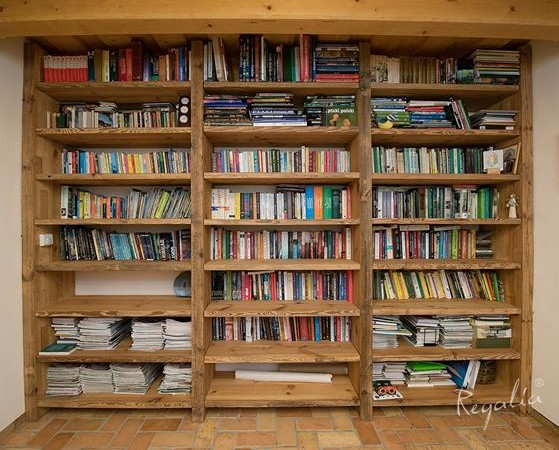 Drewniana biblioteczka na całą ścianę w salonie