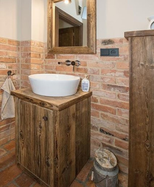 Łazienka w stylu rustykalnym z szafką ze starych desek oraz z lustrem z drewnianą ramą