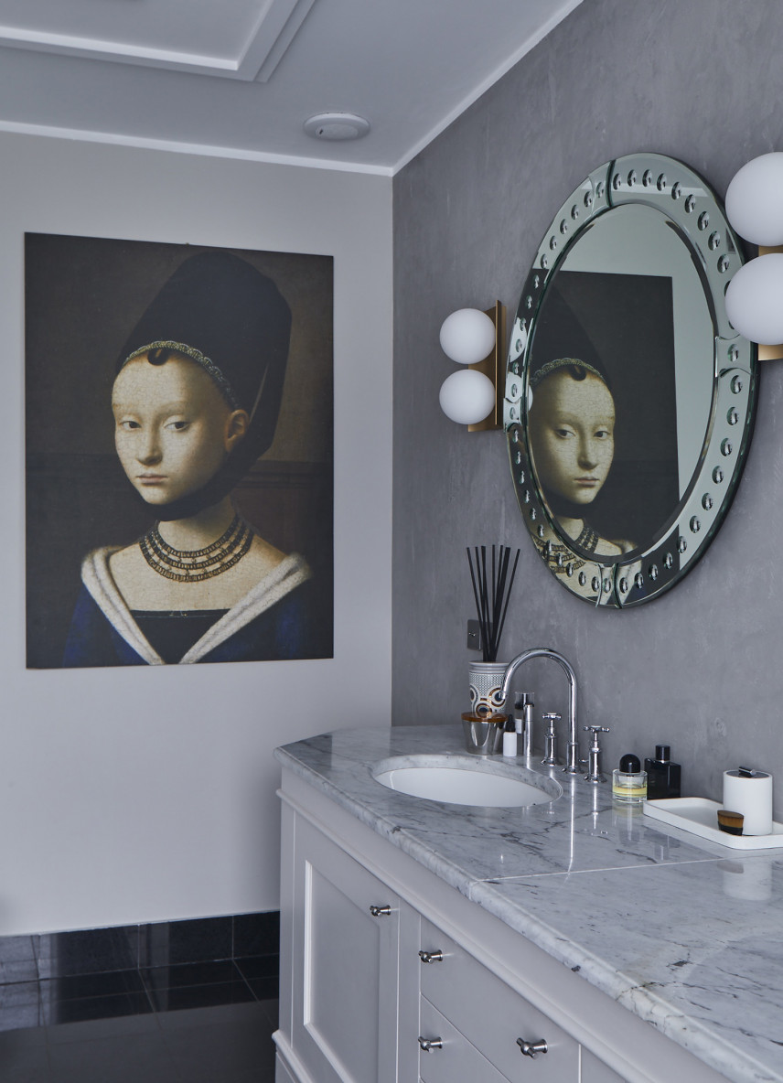 Elegancka dekoracja w postaci obrazu i oryginalnego lustra w łazience