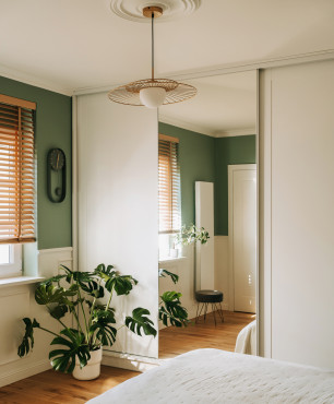 Klasyczna sypialnia z zielonym kolorem ścian oraz wyjątkową lampą wiszącą