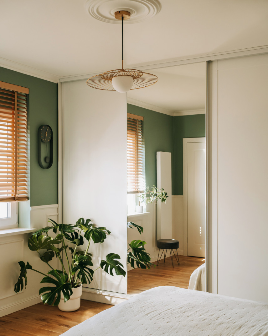 Klasyczna sypialnia z zielonym kolorem ścian oraz wyjątkową lampą wiszącą