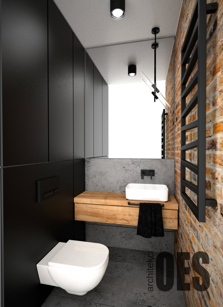 Łazienka z czarnym kolorem ściany oraz cegłą na drugiej ścianie