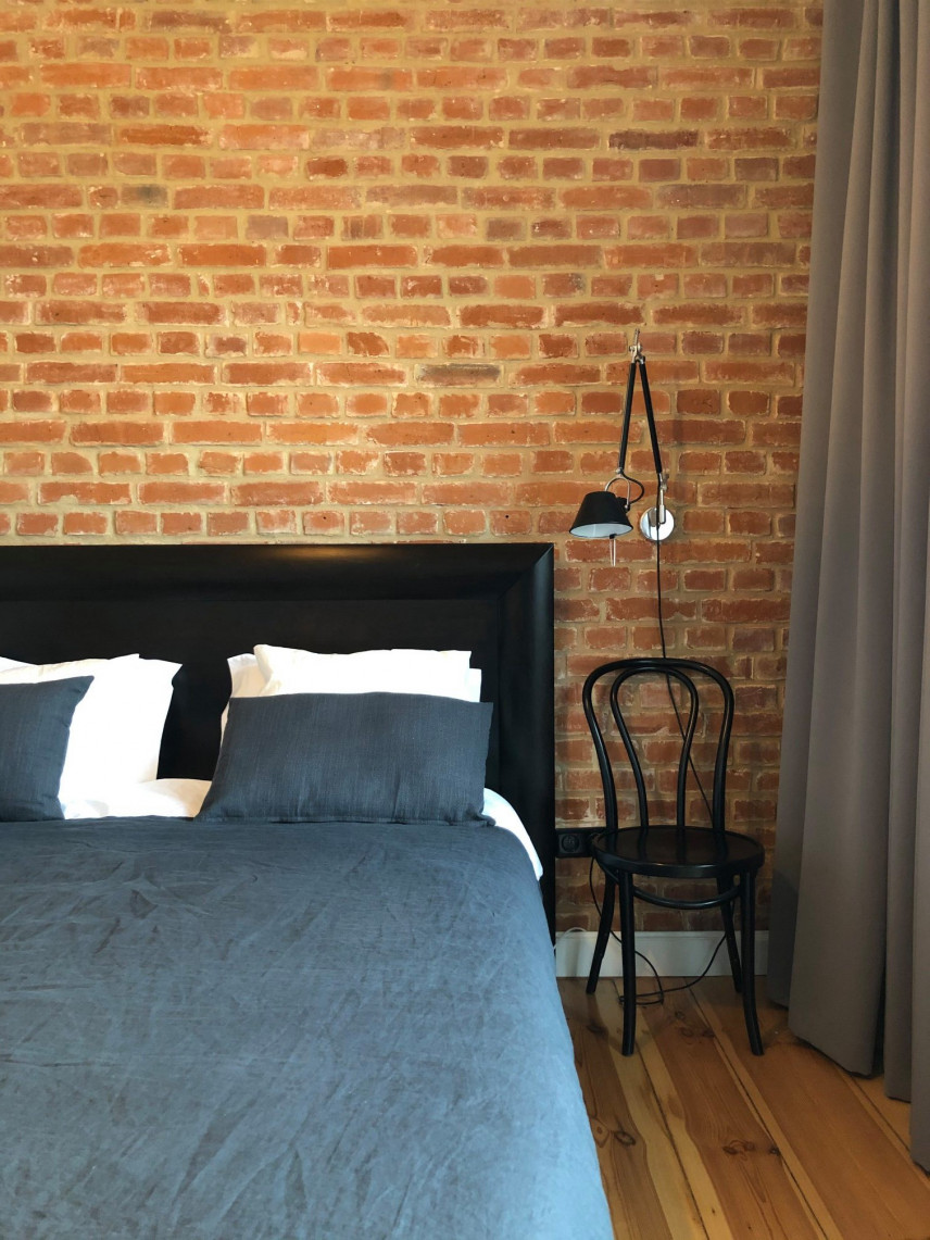 Sypialnia z czarnym, drewnianym łóżkiem kontynentalnym