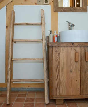 Łazienka na poddaszu z szafkami wykonanymi z drewnianych desek