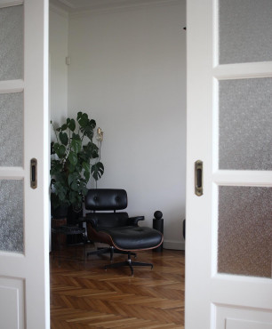 Salon z drewnianym parkietem oraz z białym kolorem ścian