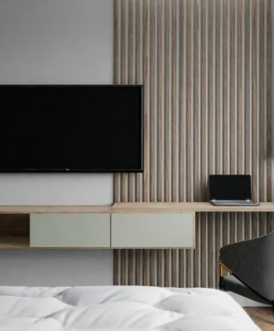 Sypialnia z lamelem drewnianym na  ścianie oraz z drewnianym blatem połączonym z szafką montowaną do ściany