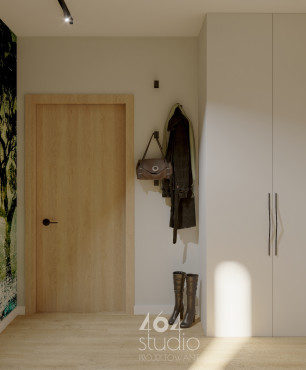 Przedpokój z białą szafa z otwieranymi drzwiami oraz z tapetą z motywem lasu