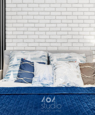 Sypialnia z białą cegłą na ścianie i z lamelem ściennym