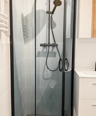 Łazienka z kabiną prysznicową oraz czarną armaturą łazienkową