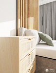 Sypialnia z drewnem na ścianie oraz drewnianą szafką nocną