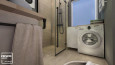 Łazienka z prysznicem z drzwiami wahadłowymi z imitacją drewnianych płytek na ścianie i podłodze