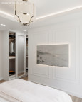 Sypialnia ze sztukaterią na ścianie oraz z szafą z białymi frontami