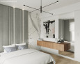 Projekt sypialni z białym kolorem ścian oraz z szarym panelem tapicerowanym usytuowanym za łóżkiem kontynentalnym