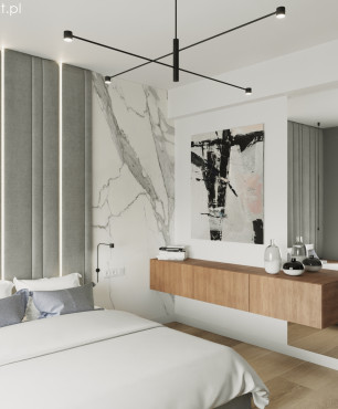 Projekt sypialni z białym kolorem ścian oraz z szarym panelem tapicerowanym usytuowanym za łóżkiem kontynentalnym