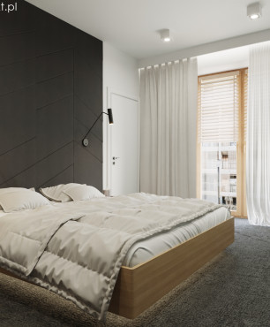 Sypialnia z czarnymi panelami na ścianie oraz z drewnianym łóżkiem kontynentalnym