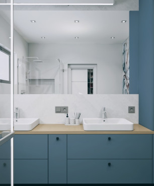 Łazienka z dwoma, prostokątnymi umywalkami nablatowymi oraz meblami z niebieskim frontem
