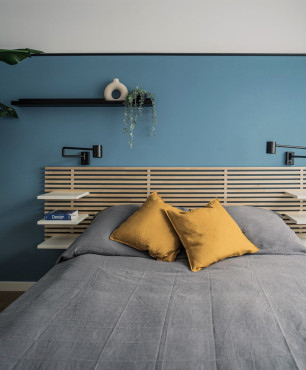 Sypialnia z błękitnym kolorem ścian oraz drewnianym łóżkiem kontynentalnym