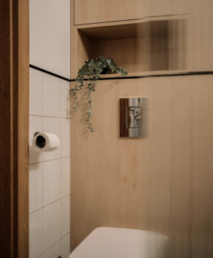 Mała łazienka z białymi i drewnianymi płytkami na ścianie