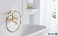 Piękna łazienka z białą, żeliwną wanną oraz stylową armaturą w kolorze złotym