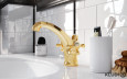Kran w kolorze złotym w łazience z białą umywalką