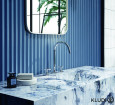 Urocza łazienka w niebieskim kolorze z kamiennym blatem z okrągłym zlewem